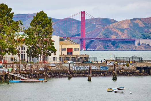 Image of San Francisco bay with tiny rowboats on water with shoreline and Golden Gate Bridge