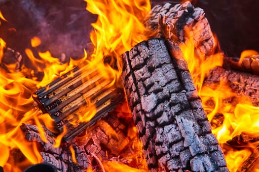 Image of Close up of destroyed wooden logs in fire with large yellow and orange flames background asset