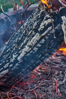 Image of Close up view of burnt log in campfire, with red embers