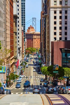 Image of Top of San Francisco hill looking down at traffic and distant Oakland Bay Bridge