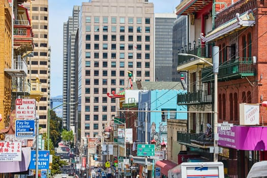 Image of Chinatown street view from atop hill looking at street signs along with shops and building mural