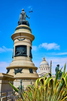 Image of Plants beside backside of Pioneer Monument with distant city hall on blue sky day