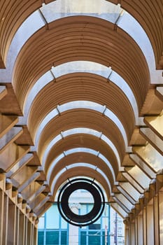 Image of Symmetrical tunnel ceiling with black circular opening at the end