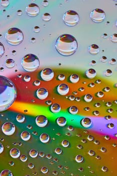 Image of Laser burst of rainbow light across reflective metallic surface with bubbles abstract asset
