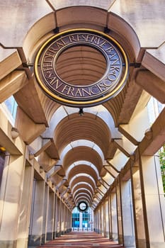 Image of San Francisco Federal Reserve Bank walkway with curved ceiling and red brick ground