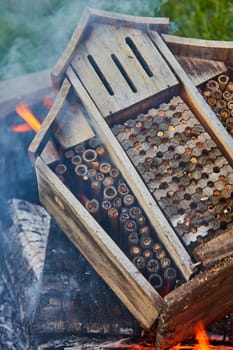 Image of Smoke flowing through burning wooden beehive with smoke and ashes