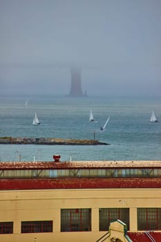 Image of Warehouse with boats on San Francisco Bay with foggy and obscured Golden Gate Bridge