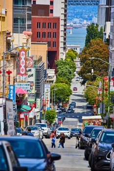 Image of Cars lining street with pedestrians crossing in Chinatown in San Francisco