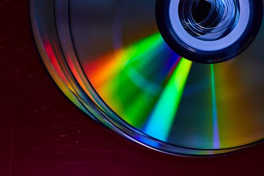 Image of Abstract stack of four bright silvery CDs with reflective rainbow colored bursts of light on surface