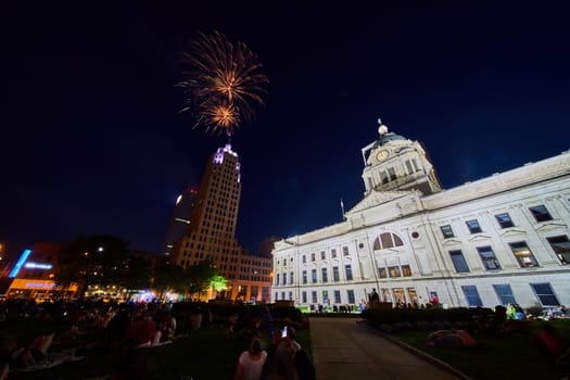 Image of Downtown Fort Wayne fireworks over Lincoln Tower with view of courthouse and lawn with crowd