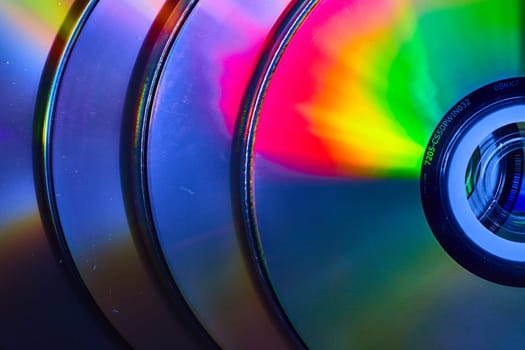 Image of Abstract stack of four CDs with reflective burst of light on surface