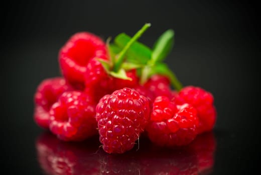 Ripe red raspberries closeup, isolated on black background.