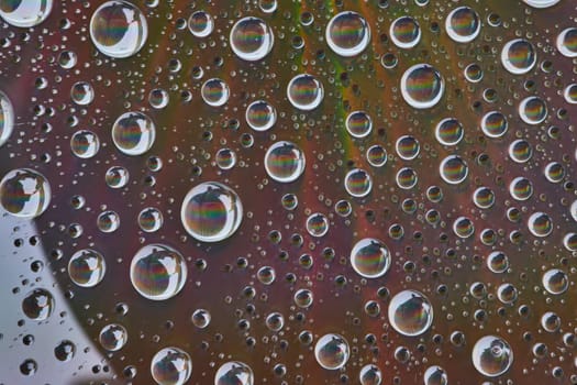 Image of Dull metallic surface with white water spheres with faded rainbows inside