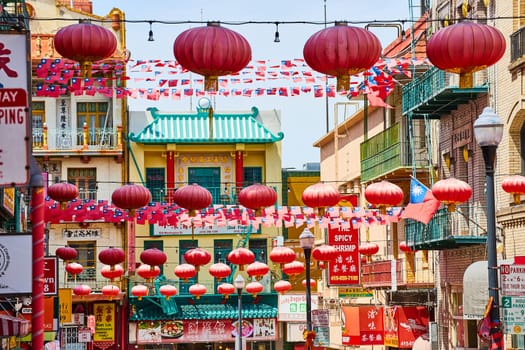 Image of Red paper lanterns with Chinese and American flags strung across road in Chinatown