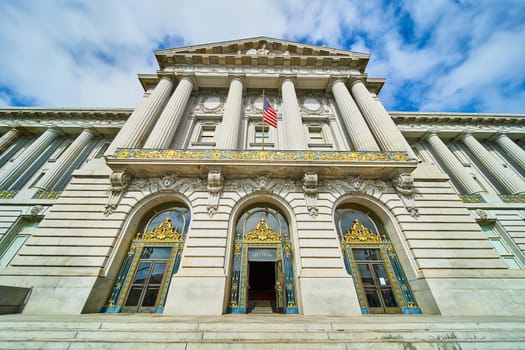 Image of Steps leading into San Francisco city hall entrance with gilded entrance and American flag