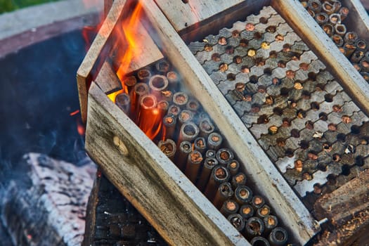 Image of Close up of burning wooden bee home with yellow and orange flames