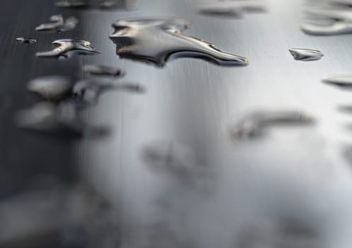 Detail of Water droplets caused by rain perched on the metallic surface. Rain water drops on a stainless steel handle, Natural Pattern of dew drops or raindrops on silver metal background for wallpaper poster and banner design, Selective focus.