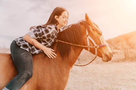 A young woman in a plaid shirt rides a brown horse with a sunset in the background.