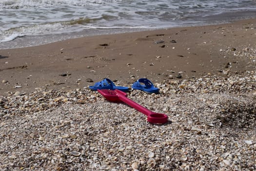 Beach background with flip flop and plastic spade. holiday and vacations concept.