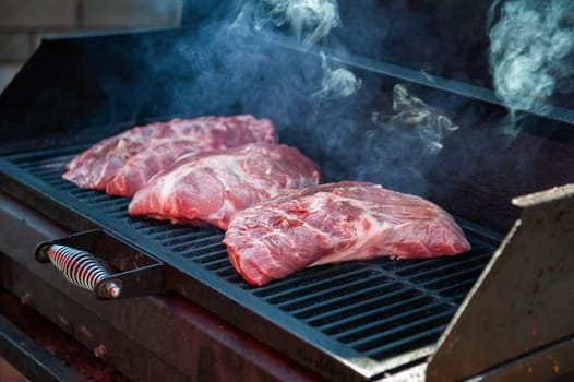 Pork meat steaks on the grill with flames