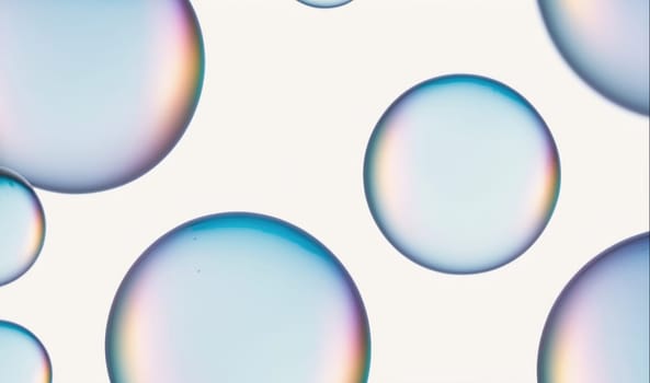 The image shows several translucent bubbles floating against a white background. The bubbles are different sizes, with the largest taking up most of the frame. The light reflects off the bubbles, creating a rainbow effect.