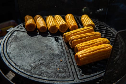 A professional cook prepares corn on the grill outdoor, food or catering concept