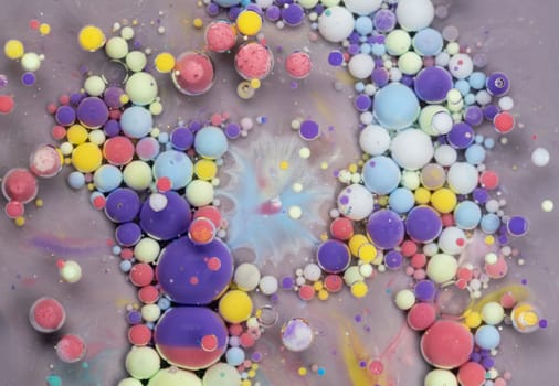 The artwork showcases an array of colorful spheres in various sizes, set against a soft gray background, creating a mesmerizing abstract pattern that draws the eye.