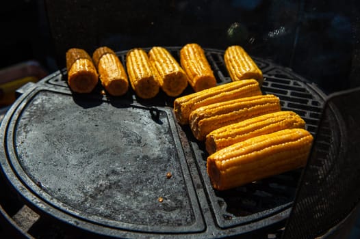 A professional cook prepares corn on the grill outdoor, food or catering concept