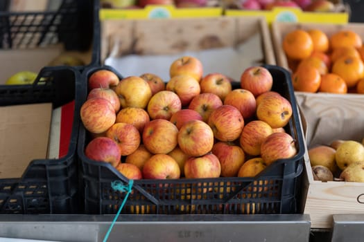 Plastic basket with apples on the market. Mid shot