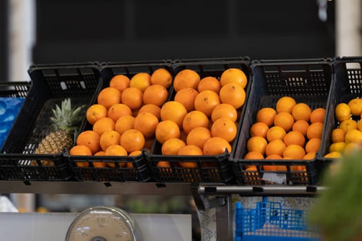 Plastic basket with tangerines and pineapple at the market. Mid shot