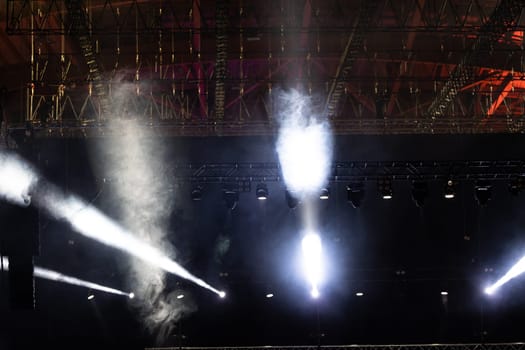 Spotlights illuminate the stage with a strong white light. Mid shot