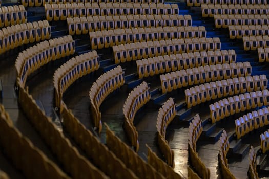 Empty seats in a large empty rounded hall. Mid shot