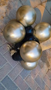 inflatable gold balloons on the ground, fence street objects. High quality photo