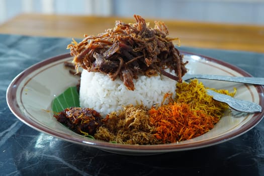 Nasi Krawu, a signature dish from Surabaya, Indonesia, featuring savory shredded beef, fragrant rice wrapped in a banana leaf, and an array of vibrant condiments - sambal, fried shallots, and turmeric.