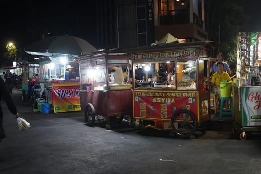 August 14, 2024. Jakarta, Indonesia. A bustling night scene in a corner of the city, filled with street vendors and shoppers.