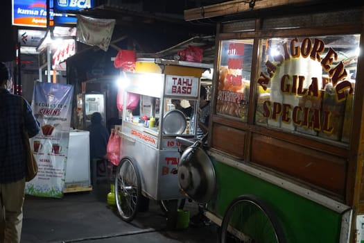 August 14, 2024. Jakarta, Indonesia. A bustling night scene in a corner of the city, filled with street vendors and shoppers.