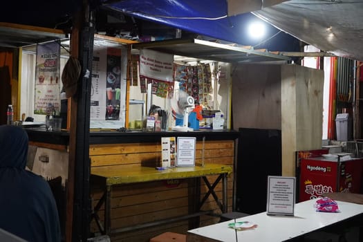 August 14, 2024. Jakarta, Indonesia. A bustling night scene in a corner of the city, filled with street vendors and shoppers.