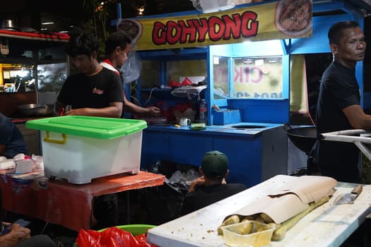 August 14, 2024. Jakarta, Indonesia. A bustling night scene in a corner of the city, filled with street vendors and shoppers.