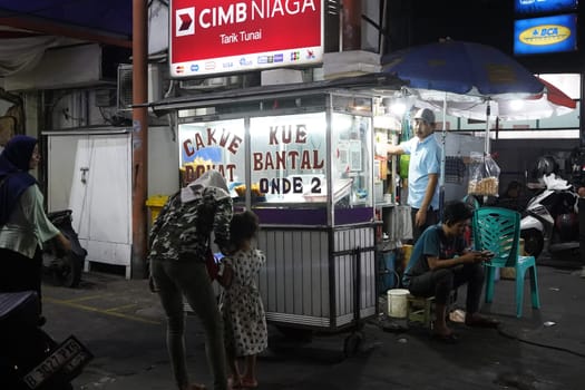 August 14, 2024. Jakarta, Indonesia. A bustling night scene in a corner of the city, filled with street vendors and shoppers.