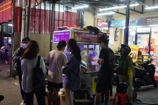 August 14, 2024. Jakarta, Indonesia. A bustling night scene in a corner of the city, filled with street vendors and shoppers.