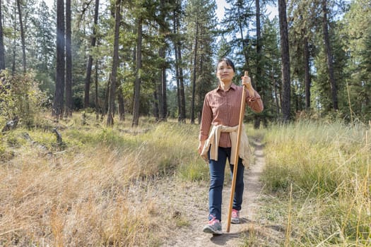 An asian woman enjoys a nice day hike at a trail near Coeur d'Alene, Idaho.