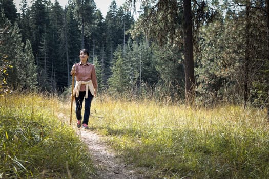 An asian woman enjoys a nice day hike at a trail near Coeur d'Alene, Idaho.