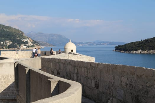Dubrovnik, Croatia, old town, roof of a house ancient stone building with a triangular facade, top view, people tourists walking April 22, 2023. High quality photo