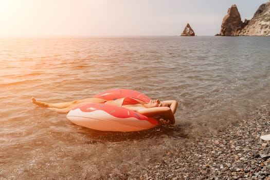 Summer Vacation Woman in hat floats on an inflatable donut mattress, a water toy swim ring. Unrecognizable young woman relaxing and enjoying family summer travel holidays vacation on the sea