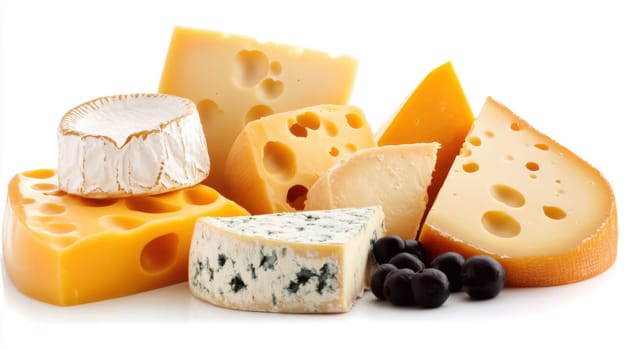 Group of various cheeses including gruyere, lavender goat cheese, provolone, parmigiano-reggiano, cheddar, and more