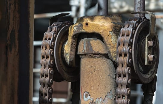 Close-up of Rusty chain on old forklift truck and lifting hydraulic cylinder. Space for text, Selective focus.