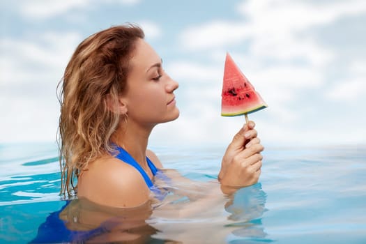 a girl in a bathing suit swims in the pool in a hot summer, a girl with a watermelon, summer holiday concept
