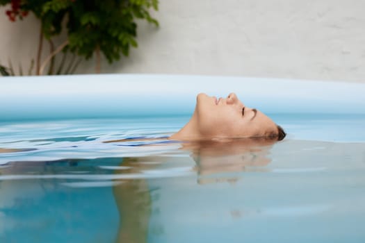 a girl in a swimsuit swims in the pool in a hot summer, the concept of a hot summer, summer holiday