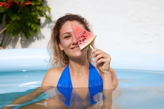 a girl in a bathing suit swims in the pool in a hot summer, a girl with a watermelon, summer holiday concept