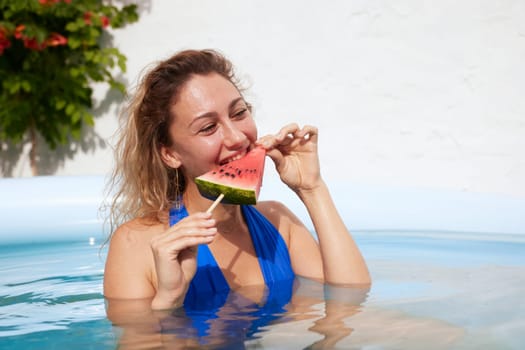 a girl in a bathing suit swims in the pool in a hot summer, a girl with a watermelon, summer holiday concept